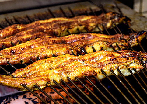 国産うなぎ通販。蒲焼きの調理画像。うなぎを綺麗な形に保つために、焼きながら金串を打つ